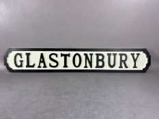 Modern wooden sign, 'GLASTONBURY'', in the form of a cast iron road sign, approx 85cm in length