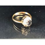 9ct Gold ring set with central large faceted gemstone and surrounded by diamonds size approx 'T'