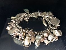 Silver charm bracelet with a large quantity of charms total weight 79g