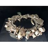 Silver charm bracelet with a large quantity of charms total weight 79g