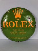 Circular green enamel sign with yellow lettering 'ROLEX', approx 30cm in diameter