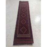 Hall carpet of Afghan style, predominant colours red and blue, approx 263cm x 61cm