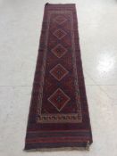 Hall carpet of Afghan style, predominant colours red and blue, approx 263cm x 61cm