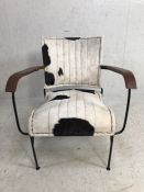 Contemporary metal framed chair with cow-hide style upholstery and wooden arm rests, approx height