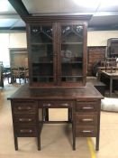 Dark oak knee hole desk, with seven drawers and associated glass fronted display unit top, desk