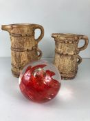 Two jugs by HISTONIA (largest 24cm tall) and a large red swirl Glass paperweight