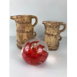 Two jugs by HISTONIA (largest 24cm tall) and a large red swirl Glass paperweight