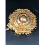 Victorian morning brooch, in gold coloured metal with glass back, safety chain fitted