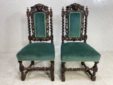 Pair of elaborately carved hall chairs, the backs with carved Green Man masks, with green velvet
