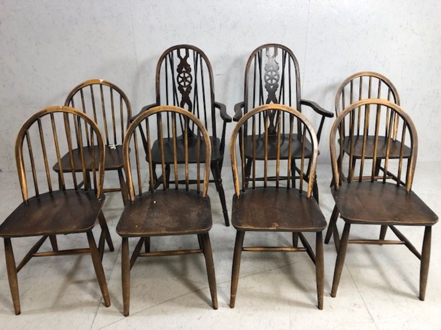 Six stick back Ercol dining chairs, and two wheel back carver chairs