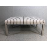 Modern Ottoman seat, upholstered in ticking style fabric on painted legs approximately 120cm x