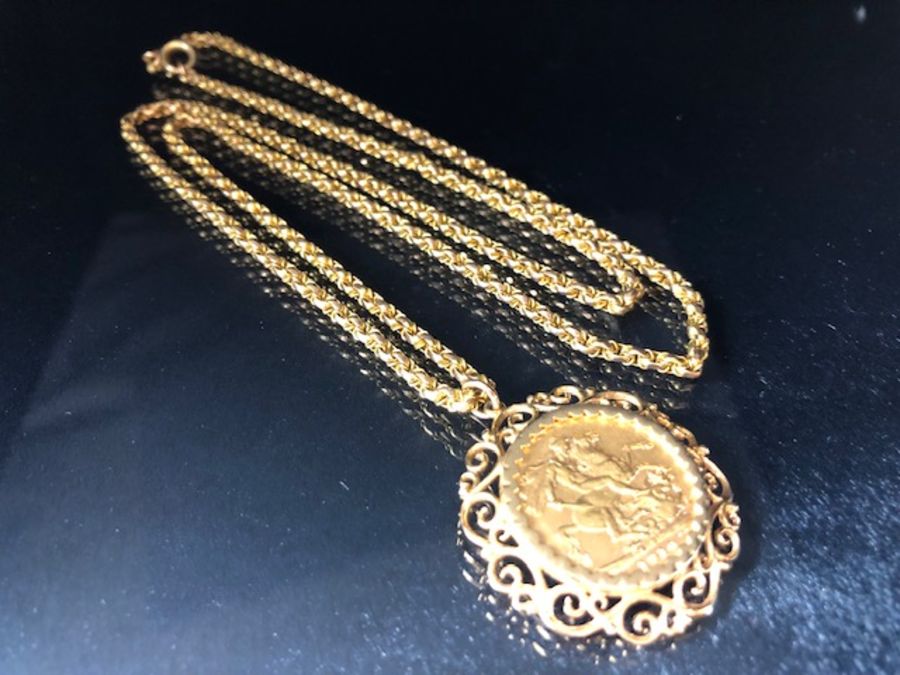 A 1910 Full Gold sovereign in a pierced and scrolling style mount on a Long 9ct Gold chain (approx - Image 6 of 8