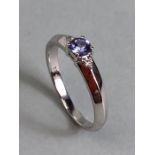 18k White gold ring set with Blue faceted Tanzanite stone and flanked by Diamond shoulders total