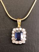 18ct sapphire and diamond pendant, cushion cut sapphire surrounded by diamonds on a rolled