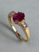 14ct Gold ring set with Oval faceted Ruby in claw setting with pair of diamonds to each shoulder