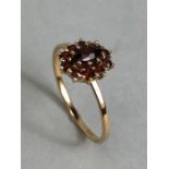 9ct Garnet cluster ring size 'P' with central oval stone surrounded by 10 smaller garnets size