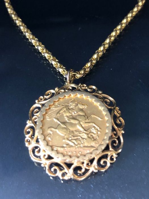 A 1910 Full Gold sovereign in a pierced and scrolling style mount on a Long 9ct Gold chain (approx
