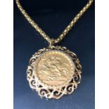 A 1910 Full Gold sovereign in a pierced and scrolling style mount on a Long 9ct Gold chain (approx