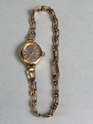 9ct Gold Oval faced watch with silver face and baton numerals on a 9ct gold gate-link bracelet strap