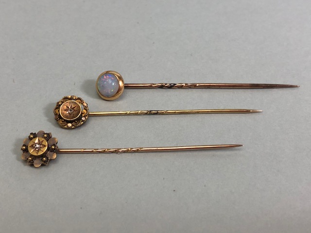 18ct Gold stick pin surmounted by an Opal with two further 15ct stick pins each set with a central