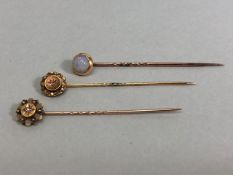 18ct Gold stick pin surmounted by an Opal with two further 15ct stick pins each set with a central