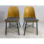 Pair of modern mustard coloured chairs with grey seat pads and matt black legs