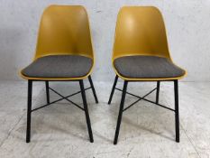 Pair of modern mustard coloured chairs with grey seat pads and matt black legs