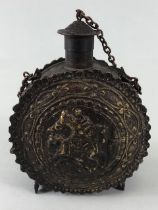 Military interest, Eastern European metal powder flask decorated with embossed geometric designs and