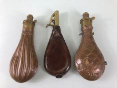 Military Interest, two copper and brass black powder flasks with embossed decoration and a leather