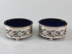 Pair of Silver salts with blue glass liners on four ball feet with pierced decoration Hallmarked for