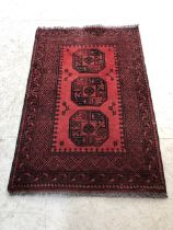 Red ground rug 100% wool with all over decoration approx 150cm x 100cm