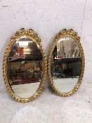 Pair of oval bevel edged gilt framed mirrors
