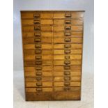 Light oak specimen cabinet with two flights of 14 narrow drawers with metal cup handles with