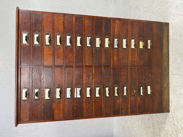 Dark stained oak specimen cabinet with two flights of 14 narrow drawers with metal cup handles