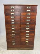 Dark stained oak specimen cabinet with two flights of 14 narrow drawers with metal cup handles