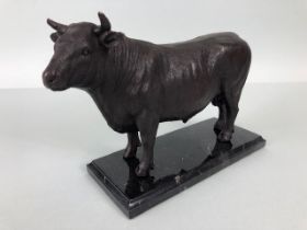 Sculpture of a standing bull in cast patinated metal on a marble base approximately 23 x 17 cm