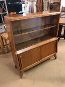 Mid Century glass-fronted bookcase with sliding doors to cupboard under, on splayed feet, approx