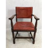 Antique red leather studded elbow chair on turned front legs with cross stretchers