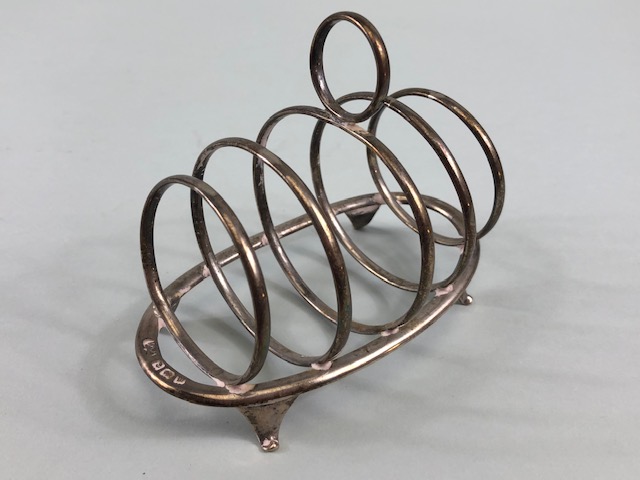Hallmarked silver toast rack with graduated circular dividers on oval base with four splayed feet