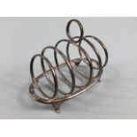 Hallmarked silver toast rack with graduated circular dividers on oval base with four splayed feet
