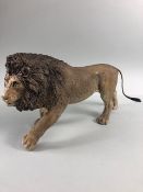 Pottery Sculpture, naturalistic unglazed sculpture of a male lion walking approximately 34cm in
