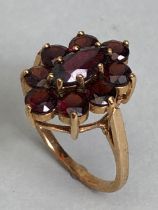 9ct gold daisy style ring set with nine garnets in claw settings with large oval central garnet on