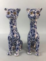Oriental China, a pair of Chinese long neck cats with cobalt decoration of leaves and tendrils the