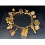 9ct Gold hallmarked charm bracelet with 9ct Gold heart shaped lock and a collection of mostly 9ct