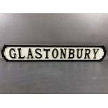 Modern wooden sign, 'GLASTONBURY'', in the form of a cast iron road sign, approx 83cm in length