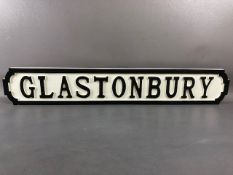 Modern wooden sign, 'GLASTONBURY'', in the form of a cast iron road sign, approx 83cm in length