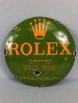 Circular green enamel sign with yellow lettering 'ROLEX', approx 30cm in diameter