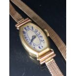 18ct ladies dress watch early 20th century, rounded lozenge shape with Arabic numerals on 9ct mesh