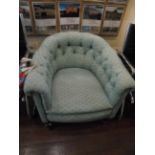 Low Victorian bow button backed armchair on pot castors, the padded arms,