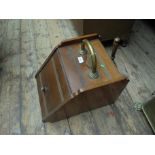 Wooden lidded coal scuttle with brass handle incorporating wooden handled shovel to rear